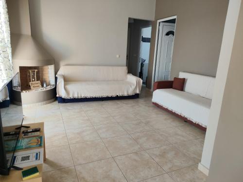 a living room with two couches sitting on a tile floor at Marinas house in Vaia