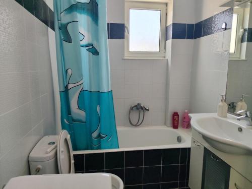 a bathroom with a toilet and a tub and a sink at Marinas house in Vaia