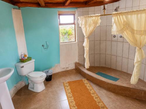 a bathroom with a tub and a toilet and a sink at Urku Ñan Quilotoa in Sigchos