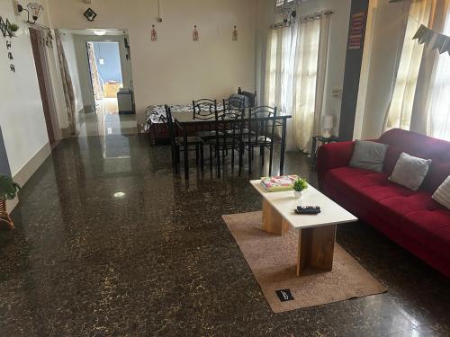 a living room with a red couch and a table at Pipitsnest 2 homes in Tezpur