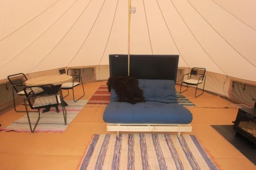 a bed in a tent with a table and chairs at Stamsjö Glamp in Åsele