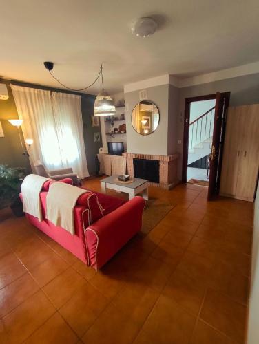 ein Wohnzimmer mit einem roten Sofa und einem Tisch in der Unterkunft El Bosque NOMADA 5 in El Bosque