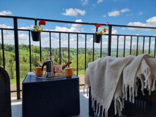 a table on a balcony with a view at Apartamenty Kaniówka 25 in Gliczarów Górny