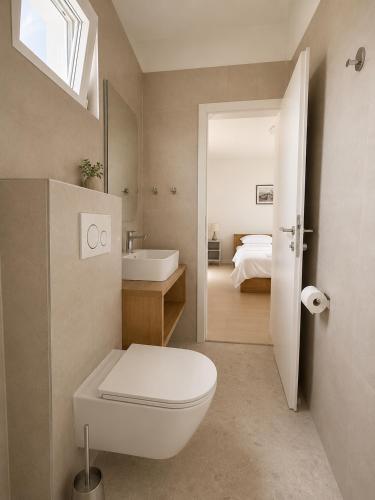 a bathroom with a toilet and a sink and a bed at Pansion Marjan in Zavala