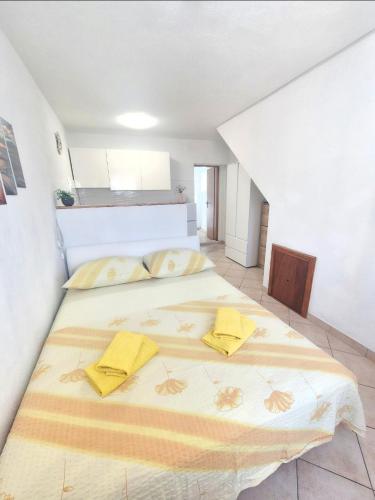 a bedroom with a large bed with yellow pillows on it at Apartments Mate in Komiža