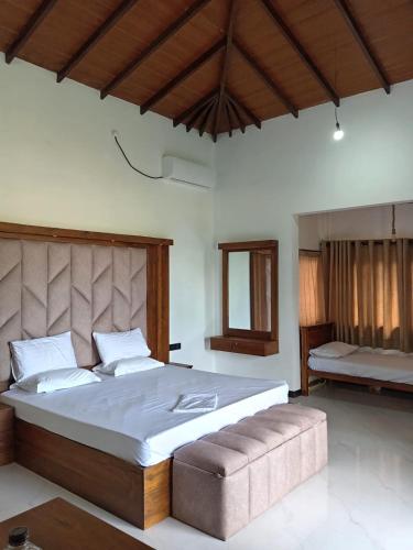 a bedroom with a large bed and a bench at Ruwan's HomeStay in Matale