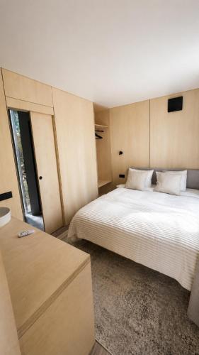 a bedroom with a large white bed and a window at Aura Glemp & SPA in Laukbeitini
