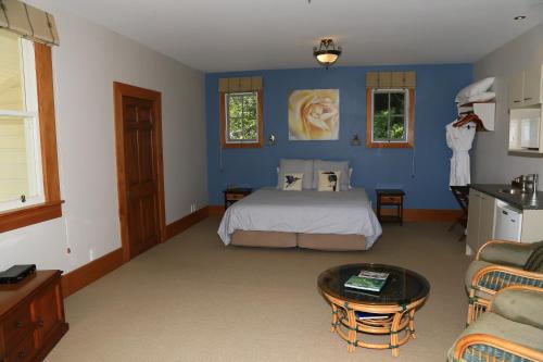 1 dormitorio con cama y pared azul en Villa Russell en Russell