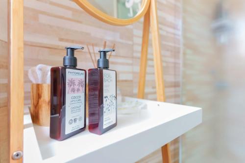 two bottles of soap on a shelf in a bathroom at Montellinos Suite Tortora in SantʼAntìoco