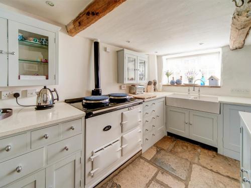 a kitchen with white cabinets and a sink at 4 Bed in Corfe Castle oc-ic126 in Corfe Castle