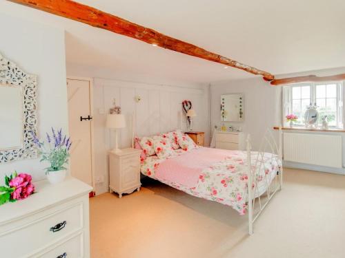 a white bedroom with a pink bed and a window at 4 Bed in Corfe Castle oc-ic126 in Corfe Castle