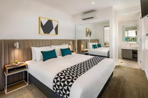 een hotelkamer met een groot bed en een badkamer bij Quest Macquarie Park in Sydney