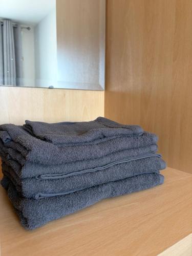 a stack of grey towels sitting on a wooden table at Double en-suite in Glin