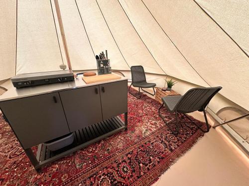 a room with two chairs and a table in a tent at Glamping de Hof van Eeden in Warmond