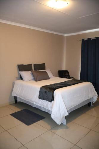 a bedroom with a large white bed in a room at MERK Guest House in Piet Retief