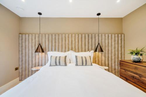 a bedroom with a large white bed with two pillows at Bell House in Amlwch