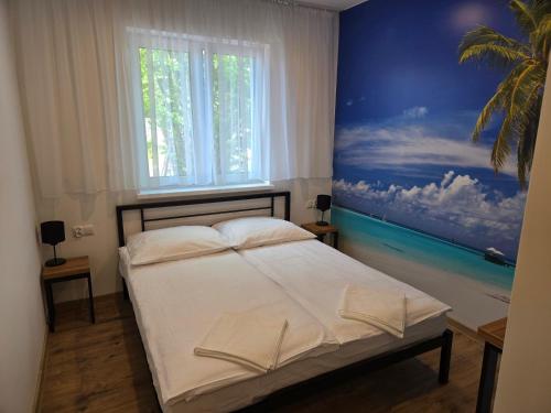 ein Schlafzimmer mit einem Bett und einem Gemälde an der Wand in der Unterkunft VUELO - shuttle gratis in Pyrzowice