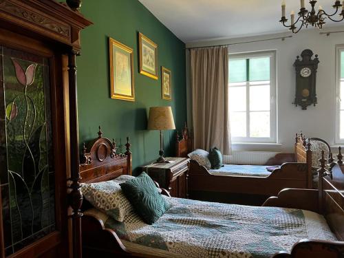 a bedroom with two beds and a clock on the wall at B&B Stare Łysogórki in Stare Łysogórki
