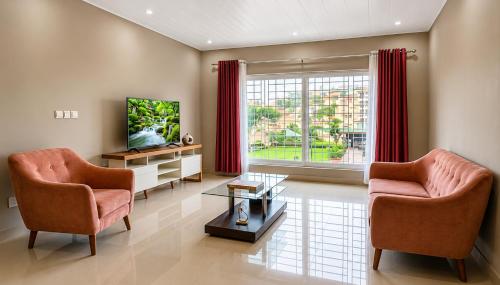 a living room with two chairs and a television at Milestone Villa in Antananarivo