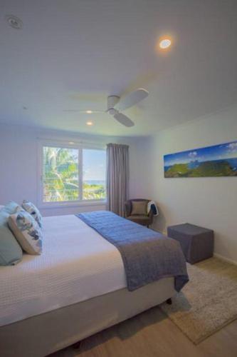a bedroom with a large bed and a window at Waimarie Apartments in Lord Howe
