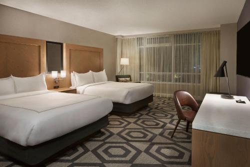 a hotel room with two beds and a chair at Caesars Windsor Hotel & Casino - A Caesars Rewards Destination in Windsor