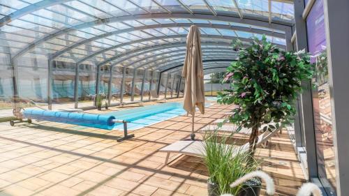 a greenhouse with a pool and an umbrella at Pino SeaView II in Gdańsk