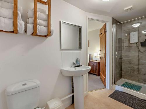 a white bathroom with a sink and a shower at 6 Bed in Filey oc-94524 in Reighton
