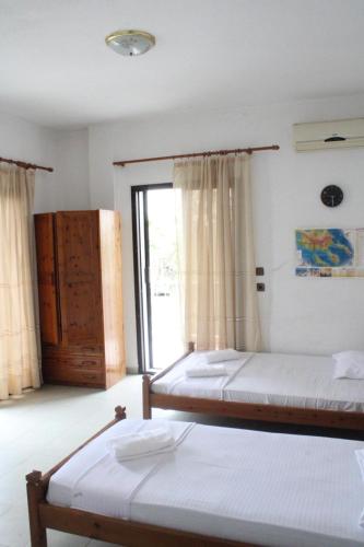 a bedroom with two beds and a window at Solis Apartments in Kallithea Halkidikis