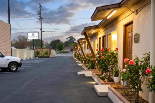 a row of buildings with flowers in a parking lot at Santa Fe Motel Tehachapi by Hotel O in Tehachapi