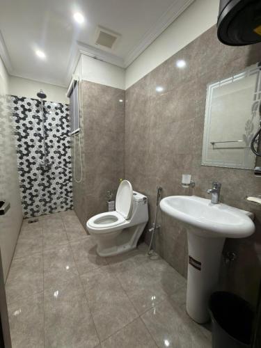 a bathroom with a toilet and a sink at Maison Eleve Residency in Lahore