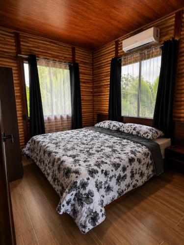 a bedroom with a bed with a black and white blanket at Cabaña Cadete in San Pedro