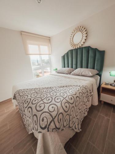 a bedroom with a large bed with a green headboard and a mirror at Marias Apartment Parque Mateo in El Rodeo