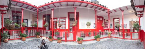 a red building with potted plants on it at Hotel La Casona in Jardin