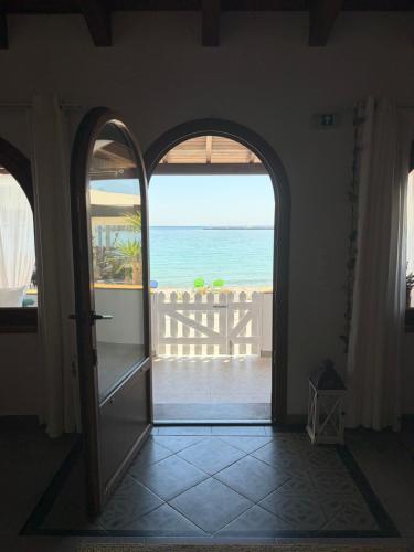 an open door to a balcony with a view of the ocean at Beachfront House Pythagorion in Pythagoreio