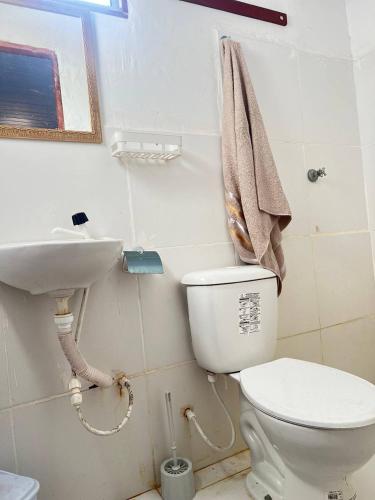 a bathroom with a white toilet and a sink at Chalé Mar Aberto in Atins