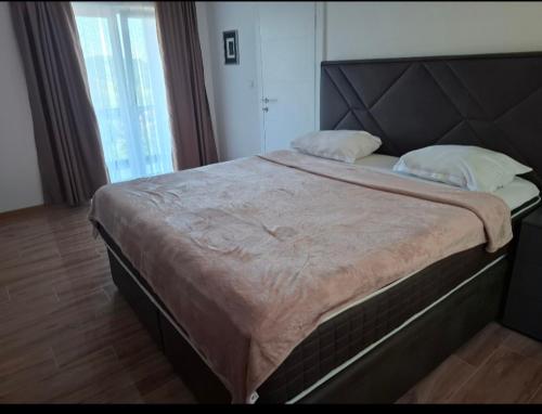 a large bed in a bedroom with a large window at Villa Aqua Tuzla in Drenovik