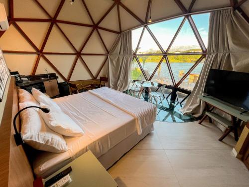 a room with a bed and a large window at Ville do Lago in Gravatá