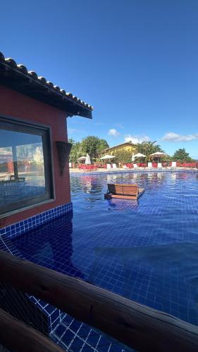 a pool of water with a building and a window at Villas do Pratagy Bambu 2 in Maceió