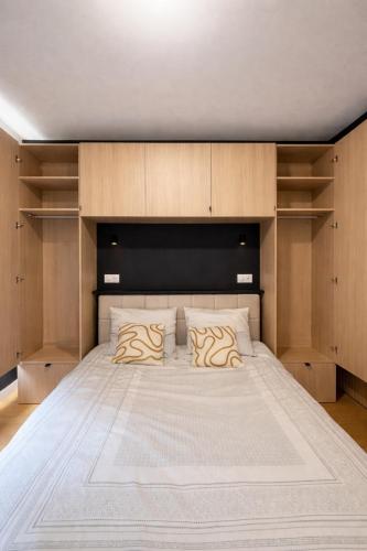 a bedroom with a large bed with wooden cabinets at Appartement neuf & élégant- Centre Lorient in Lorient