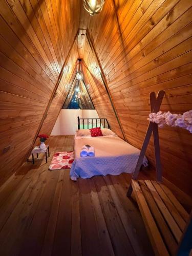 a bedroom with a bed in a wooden room at La Nebulosa Glamping in Vergara