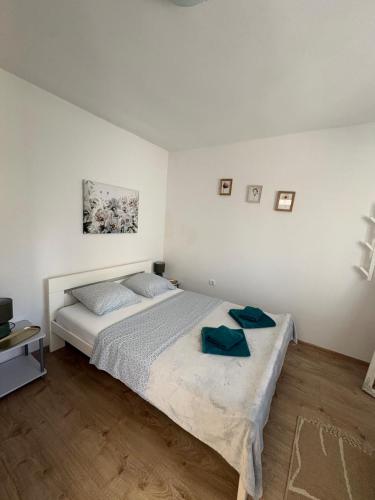 a bedroom with a bed with two blue towels on it at Apartman Velina in Pakoštane