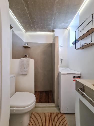 a white bathroom with a toilet and a sink at Casa Horizon in Porto Heli