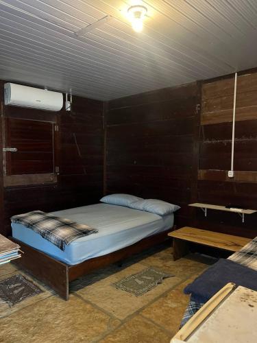 a bedroom with a bed in a wooden wall at Chalé Mar Aberto in Atins