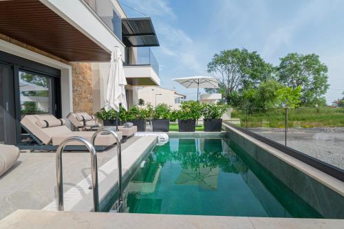 a swimming pool in the backyard of a house at Trithiron Luxury Villas in Nea Moudania