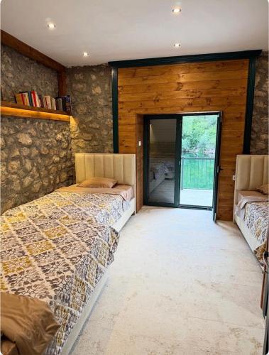 a bedroom with two beds and a stone wall at Skadar Lake Hideaway in Karuč