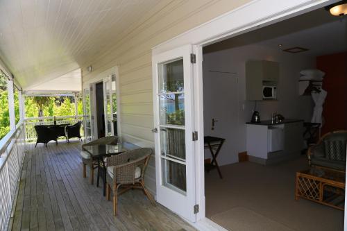 a porch with a door and a table and chairs at Villa Russell in Russell