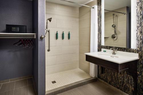 a bathroom with a sink and a shower at Hotel Alex Johnson Rapid City, Curio Collection by Hilton in Rapid City