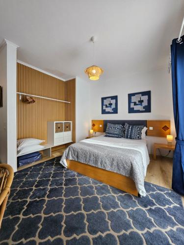 a bedroom with a large bed and a blue rug at Farol Guesthouse in Angra do Heroísmo