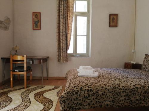 a bedroom with a bed and a window and a desk at Courtyard Cottage in Athens
