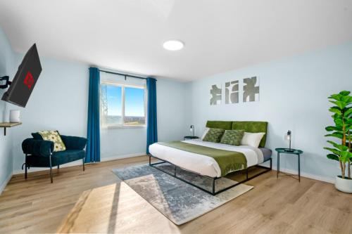 a bedroom with a bed and a chair at Spacious 5BR, Hot Tub and Pool Table - Sleeps 16 in YYC